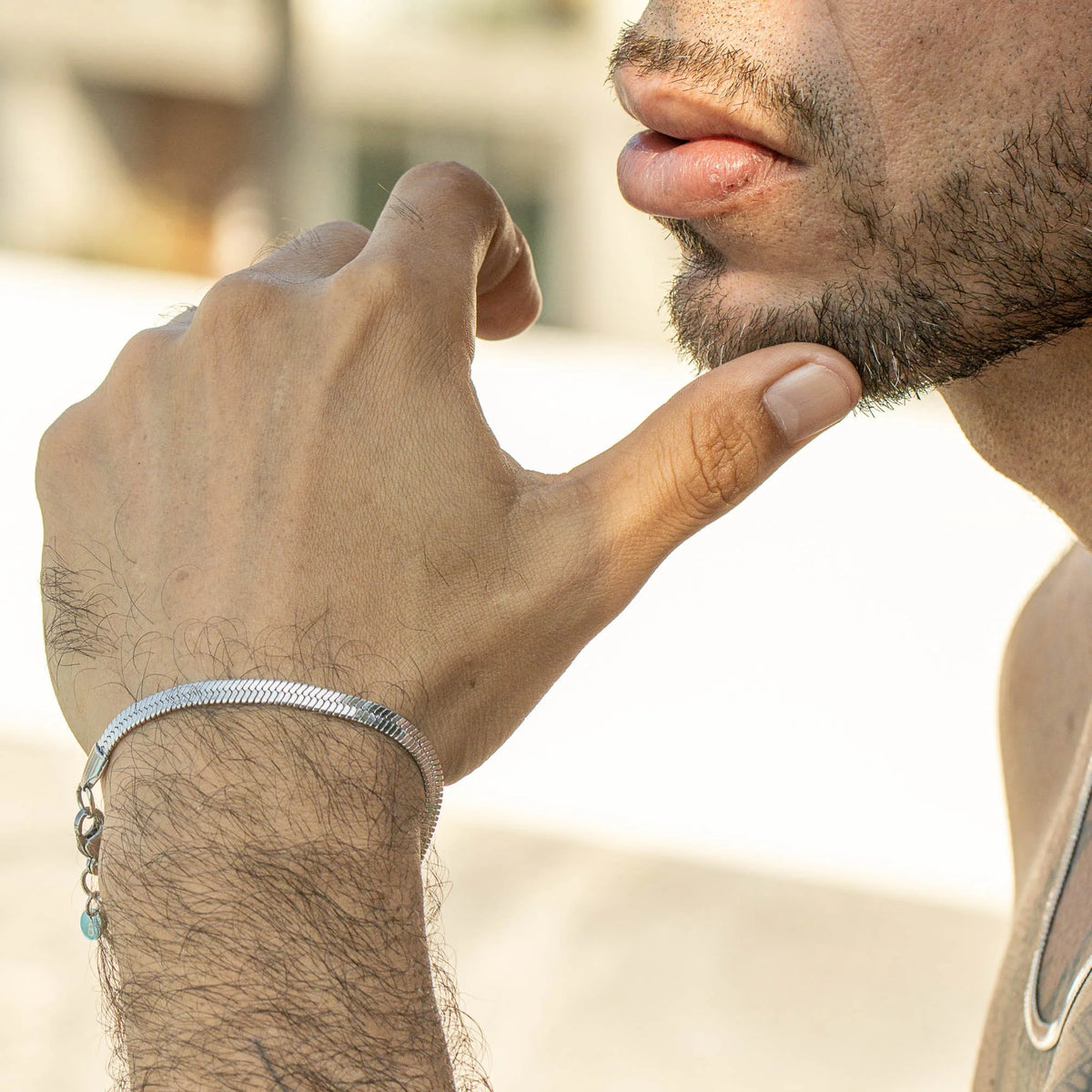 Silver bracelet with turquoise accent worn on a hairy wrist.