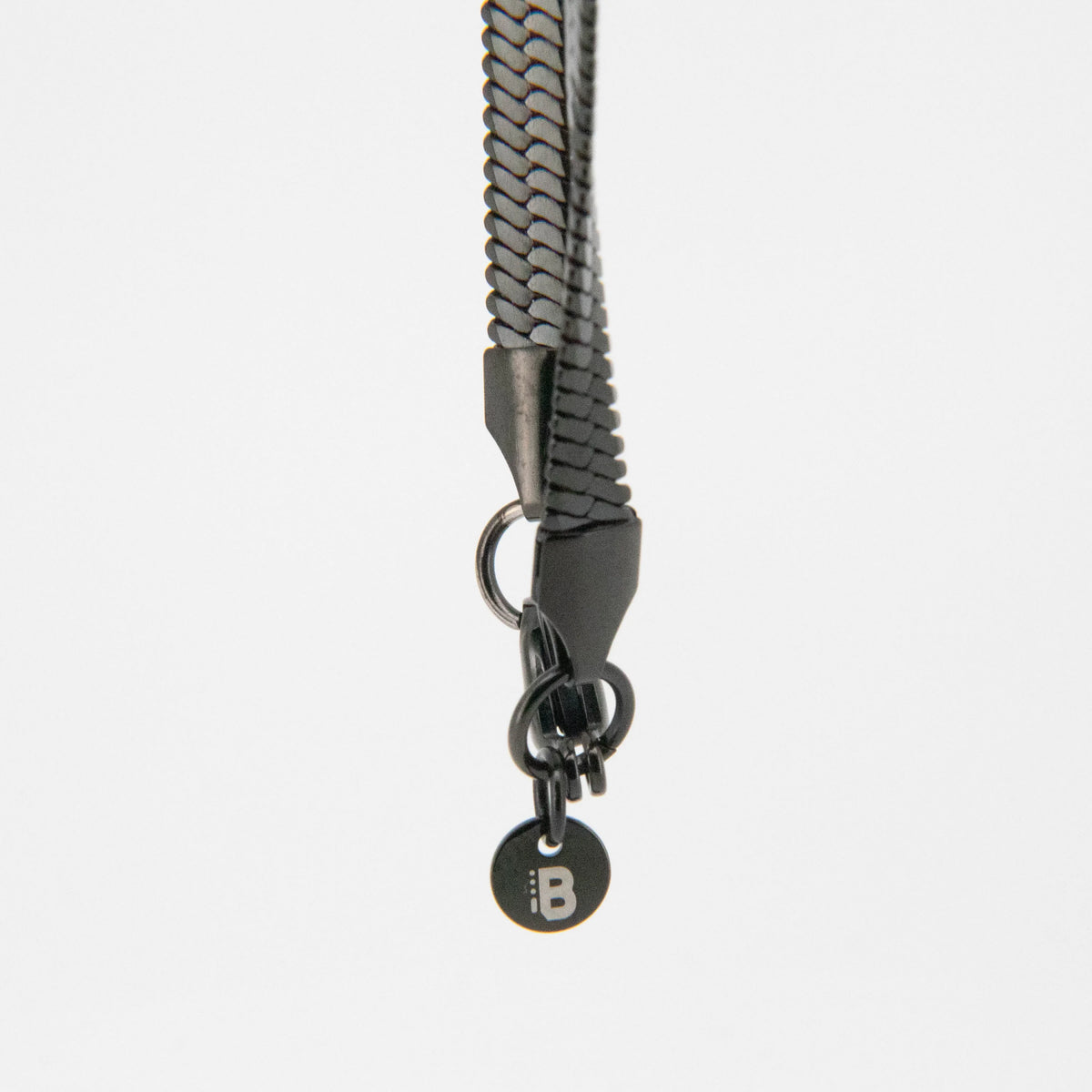 Black braided leather keychain or bag charm with metallic hardware and a branded tag.