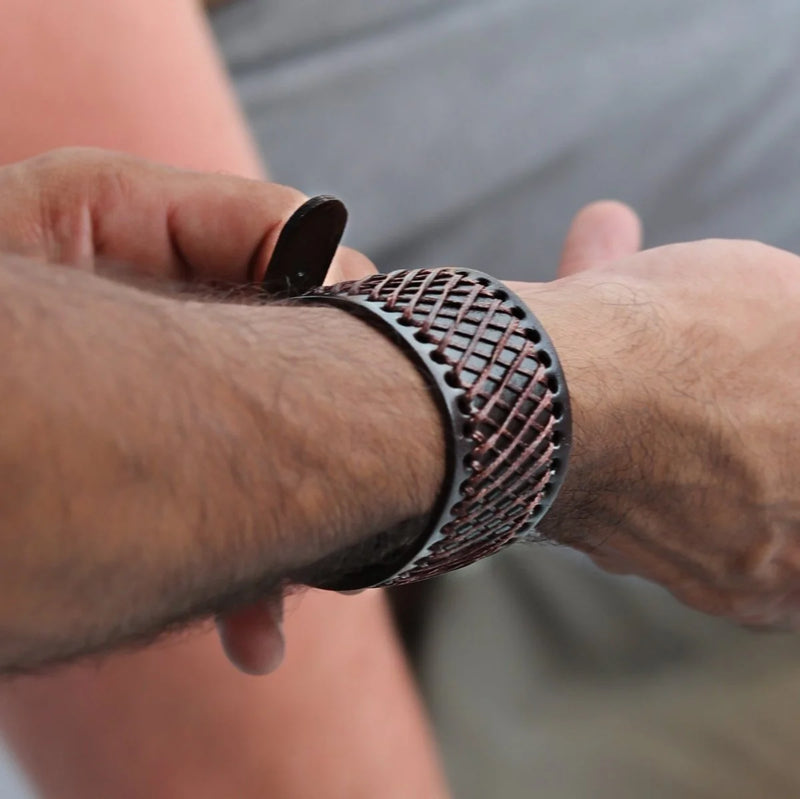 Latticed metal bracelet or cuff worn on a wrist.