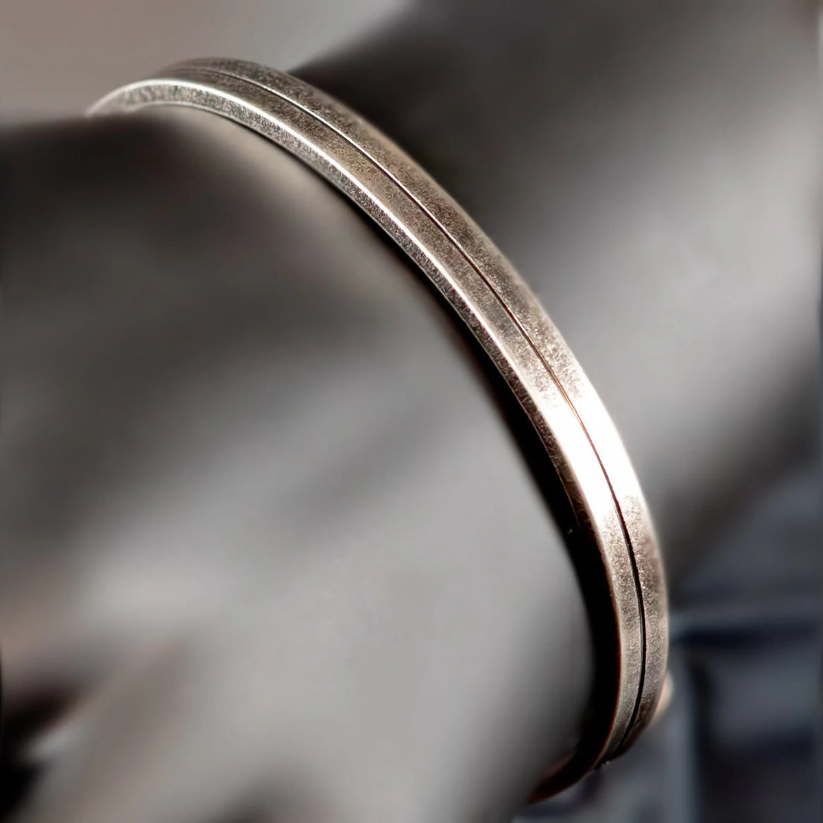 Silver metal ring with a subtle groove along its circumference.