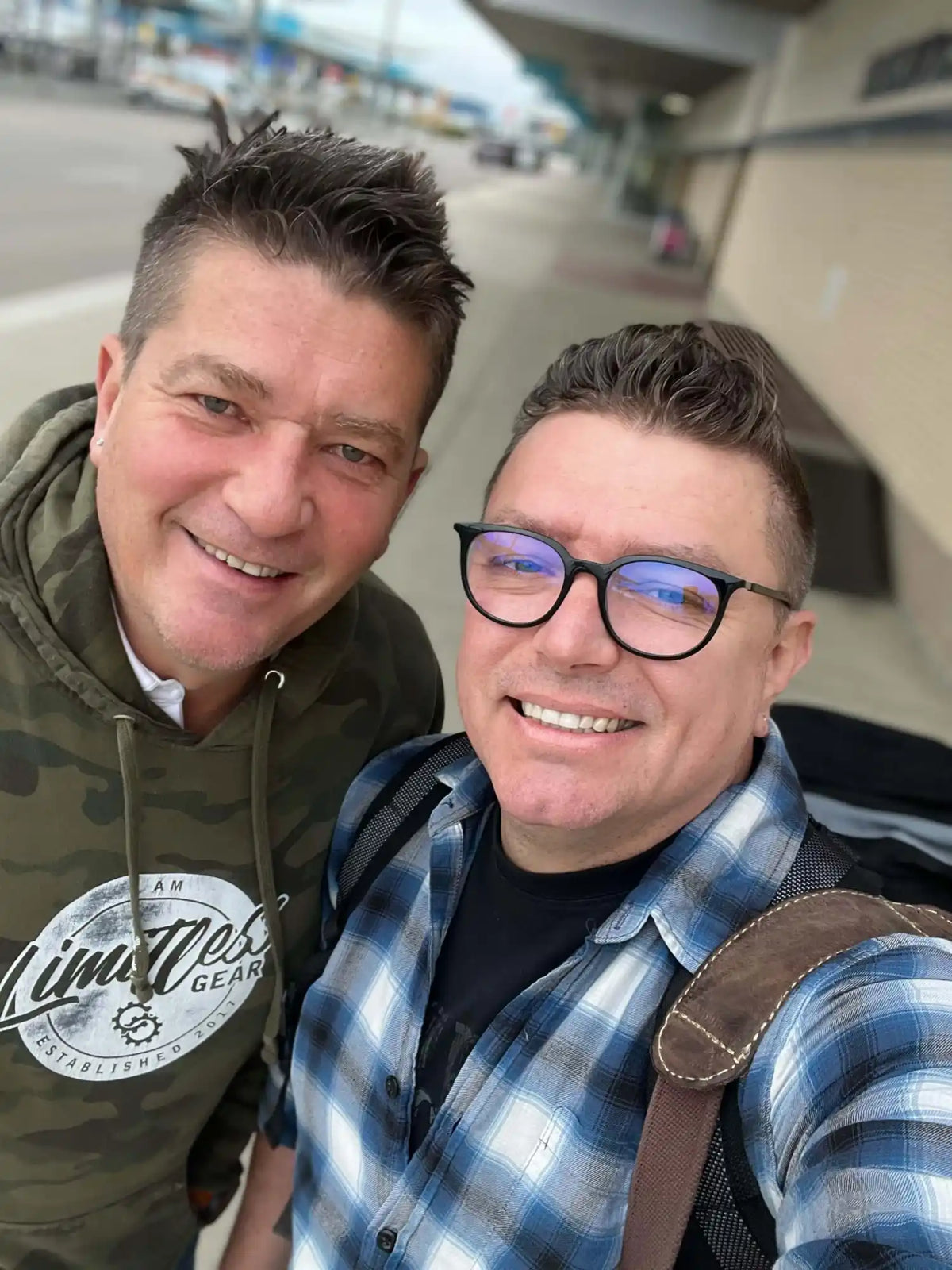 A selfie of two people wearing casual attire and smiling at the camera.