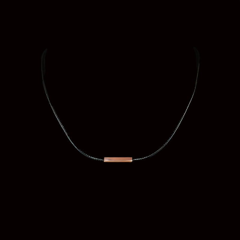 Delicate necklace with a thin chain and small copper-colored bar pendant.