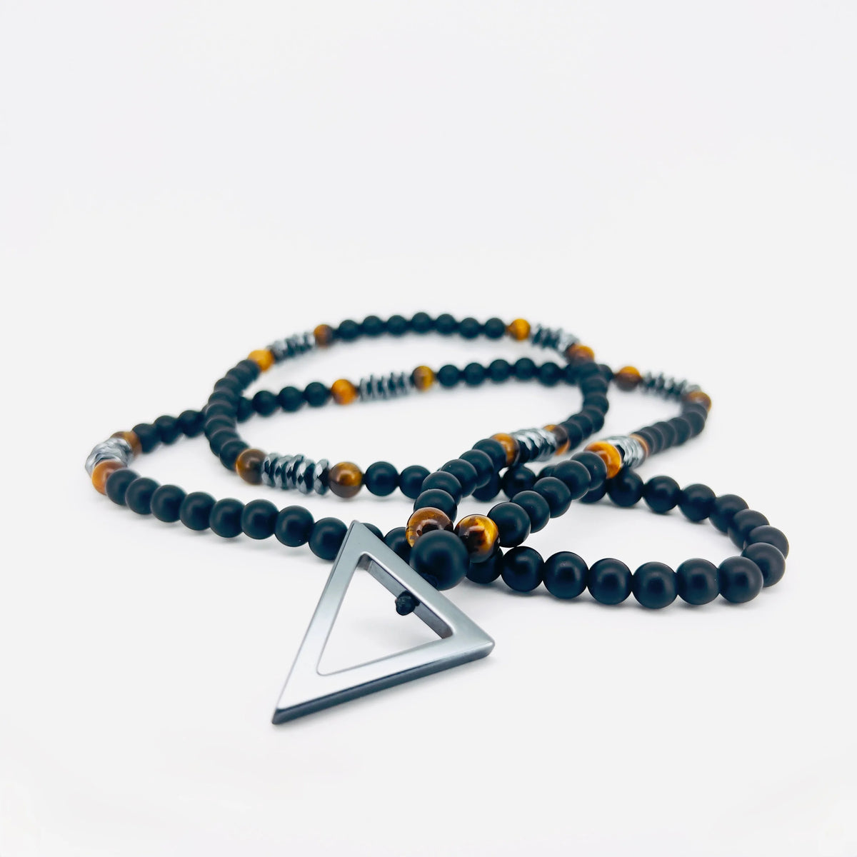 Beaded necklace with a triangular metal pendant.