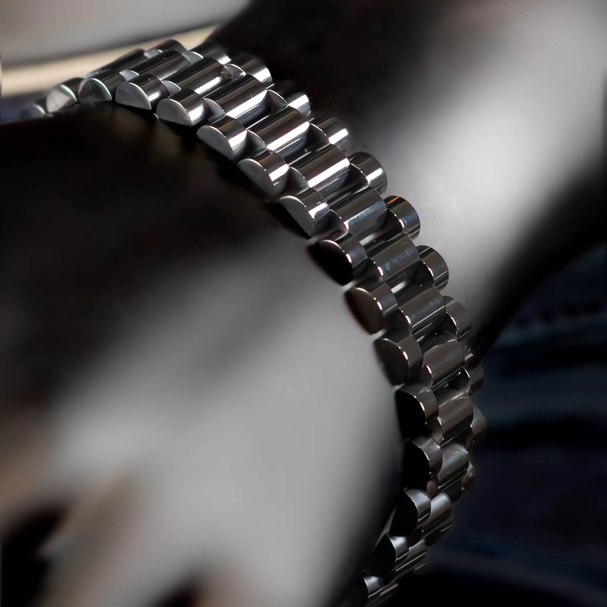 Metal watch bracelet with polished, interlocking links.