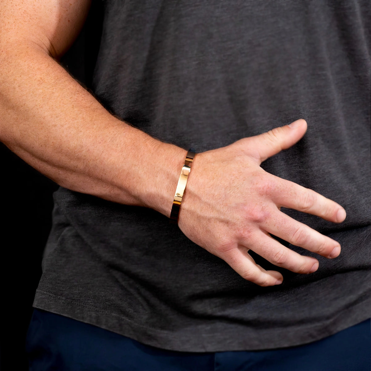 Gold metallic bracelet worn on a wrist.