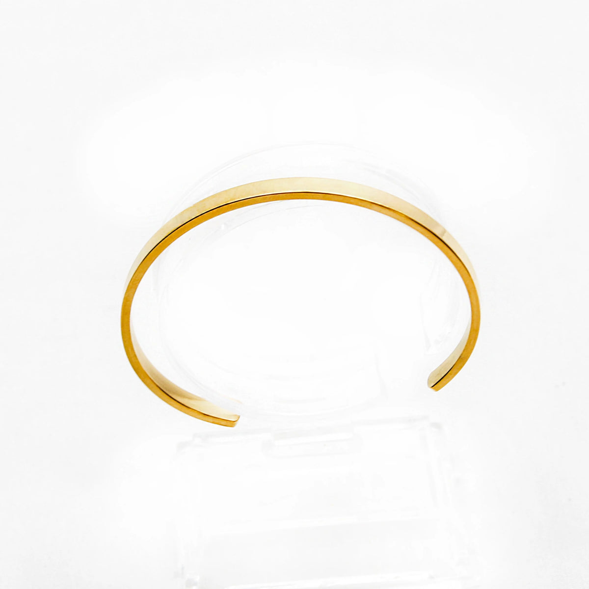 Simple gold-toned metal cuff bracelet with an open design.