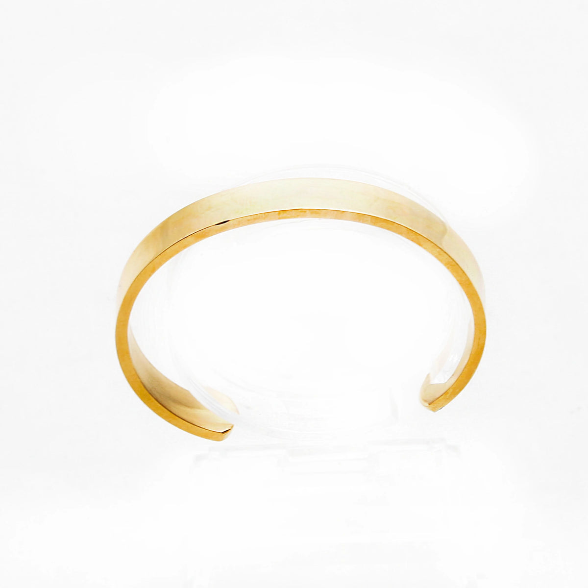 Simple gold-toned metal cuff bracelet with an open design.