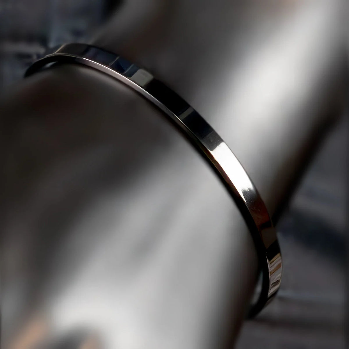 Shiny metallic bracelet or bangle with a smooth, curved surface.