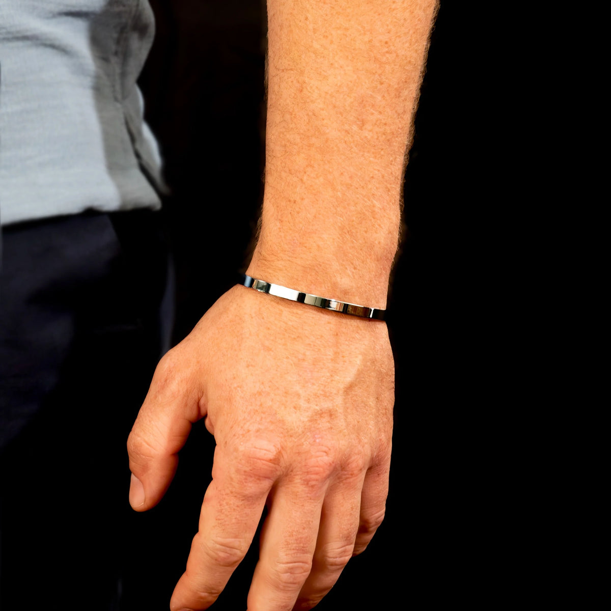 Black and gold metallic bracelet worn on a wrist.