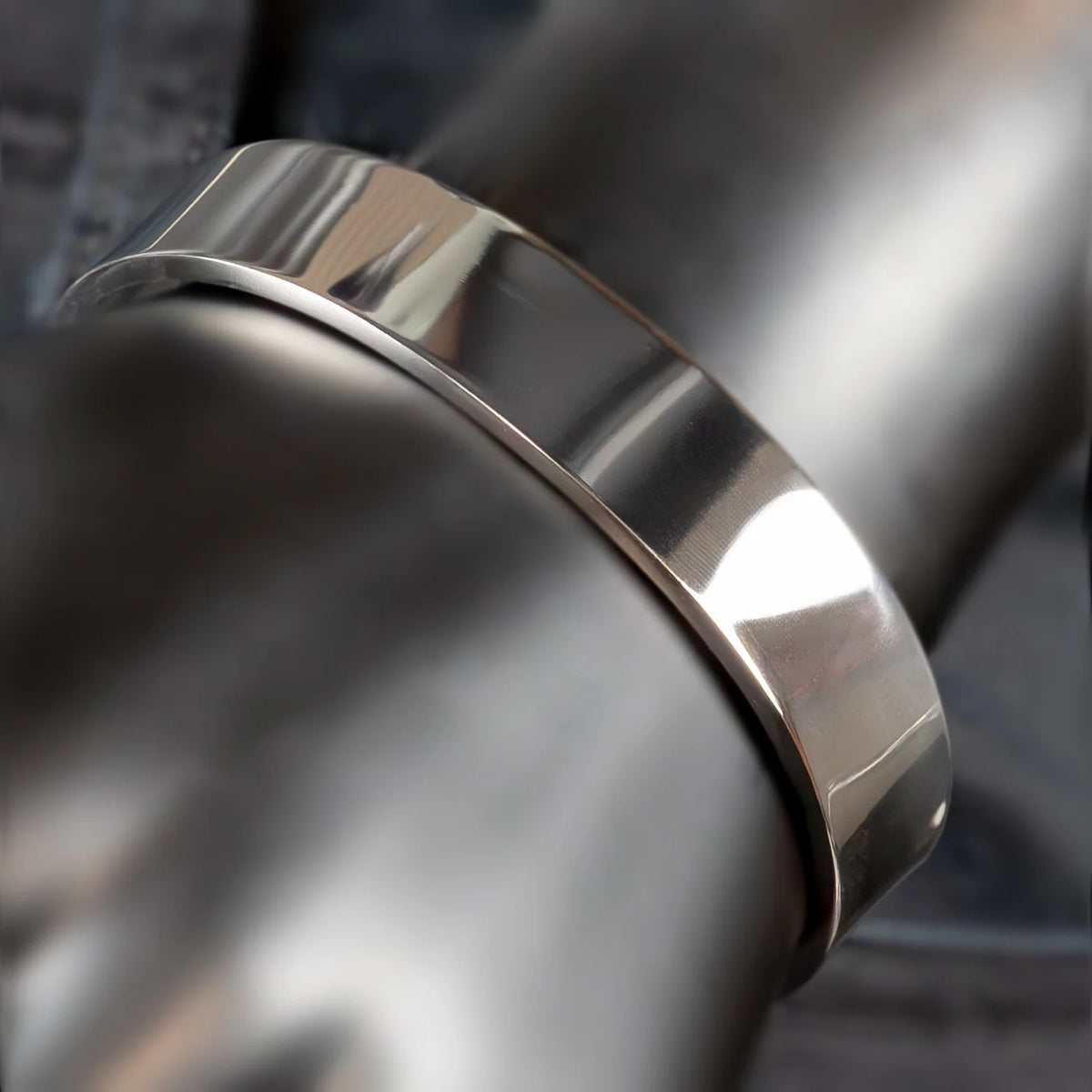 Polished silver metal ring or band with a smooth, reflective surface.