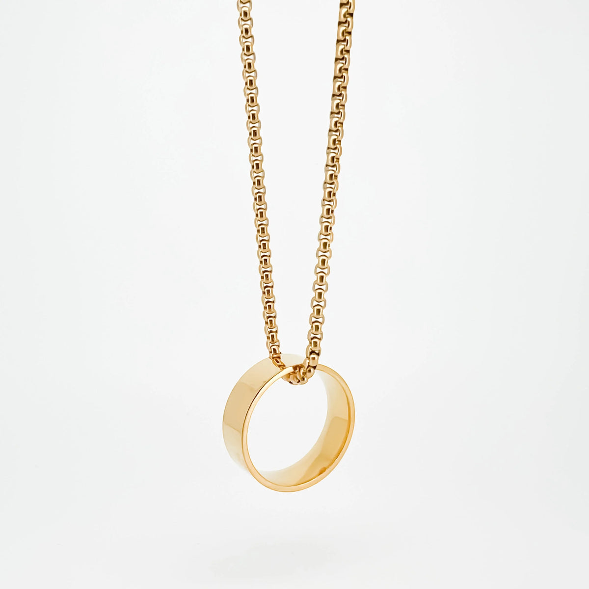 Gold-colored ring pendant on a chain necklace.