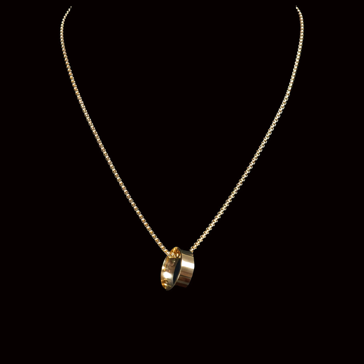 Gold necklace with a ring pendant.