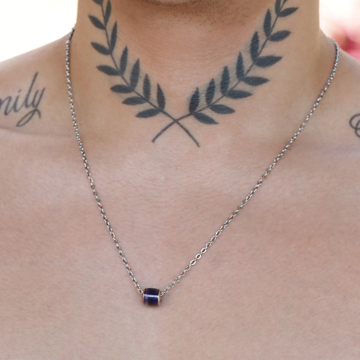 Silver necklace with a small blue pendant.