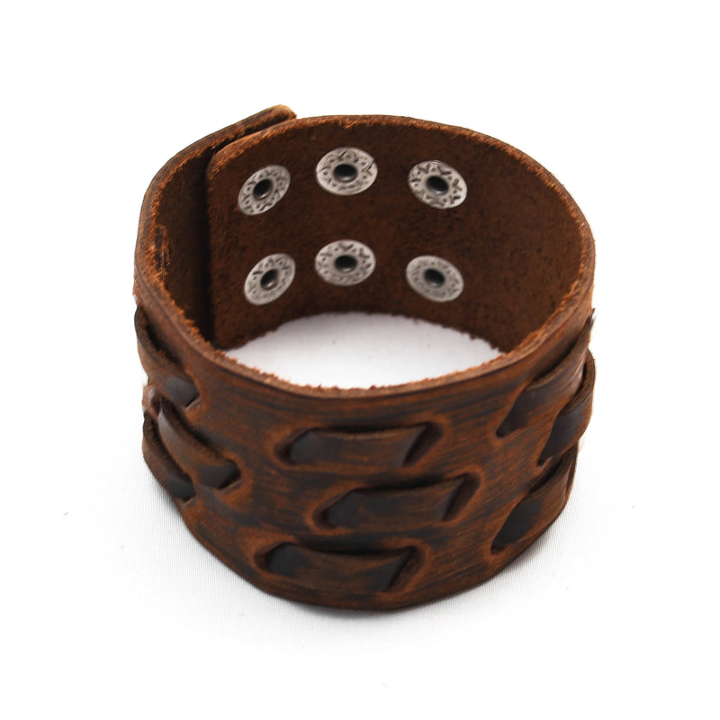 Brown leather cuff bracelet with metal rivets and a geometric pattern.