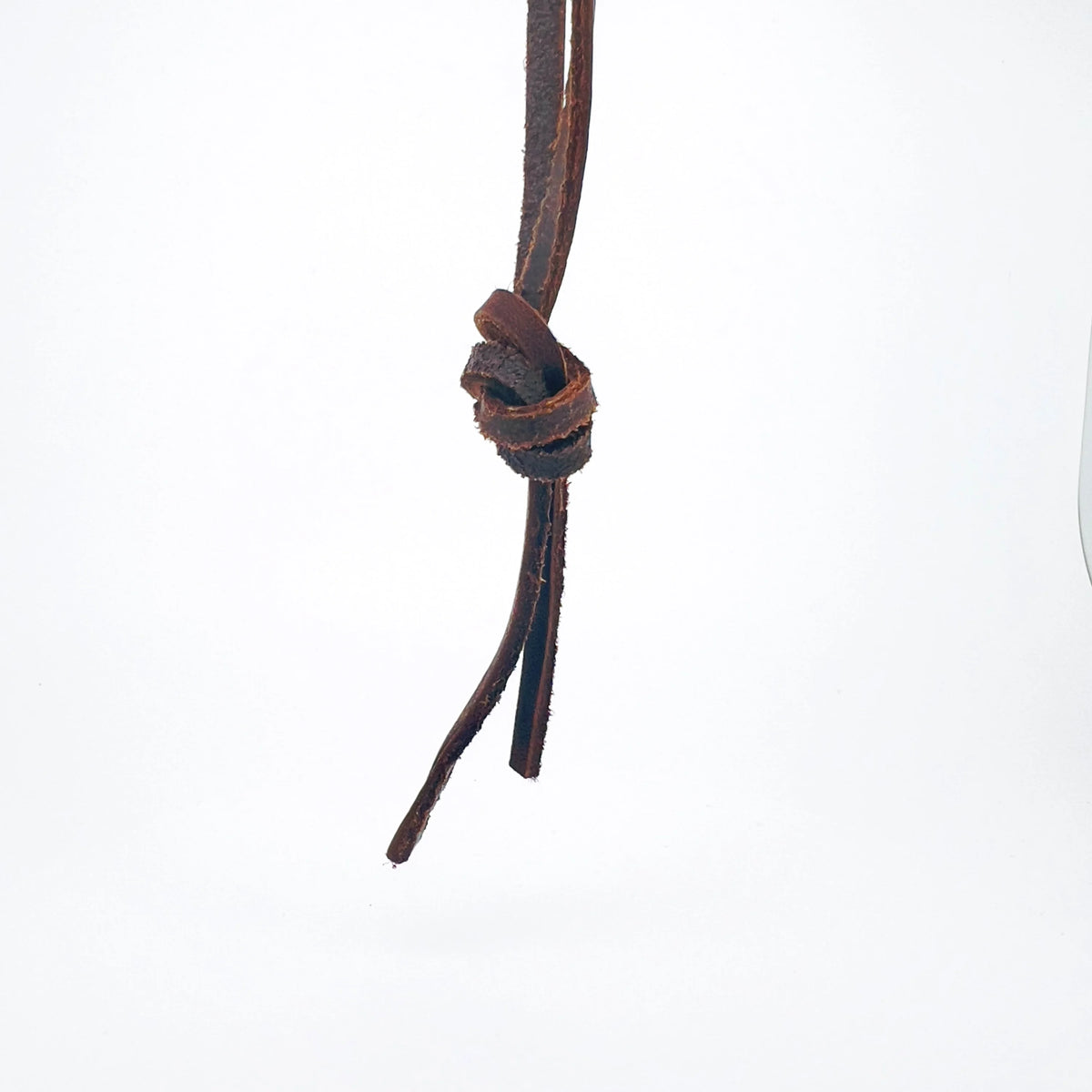 Knotted leather cord or strap with loose ends hanging down.