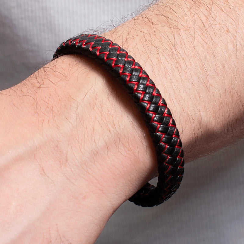 Braided black and red leather bracelet worn on a wrist.