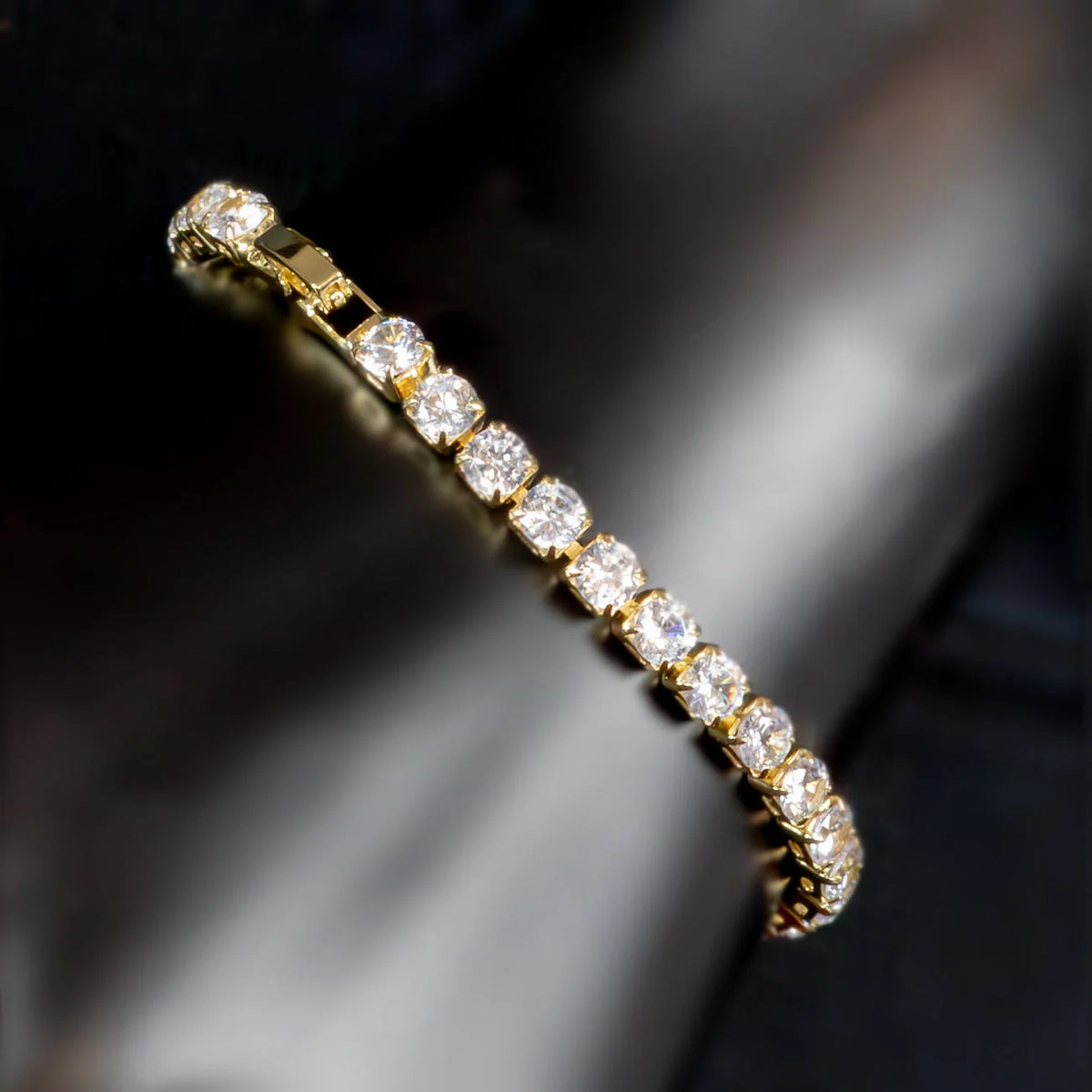 Gold bracelet adorned with a row of sparkling diamonds.