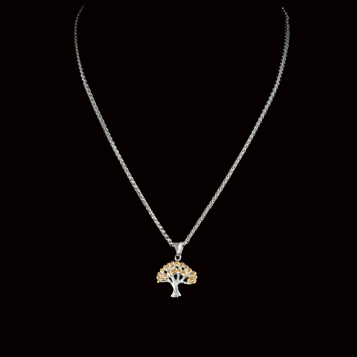 Tree-shaped pendant necklace with a silver chain and gold-colored foliage.